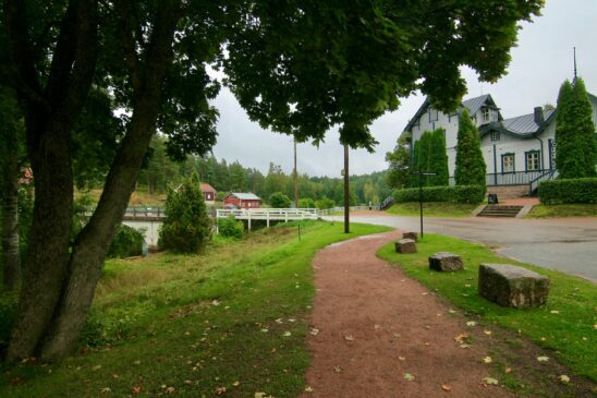 Puistopolku suuren lehtipuun alla, Patruunan pytinki ja valkoinen silta Verlassa.